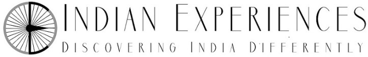 Logo of Indian Experiences, featuring a stylized wheel and text that reads 'Indian Experiences: Discovering India Differently'.